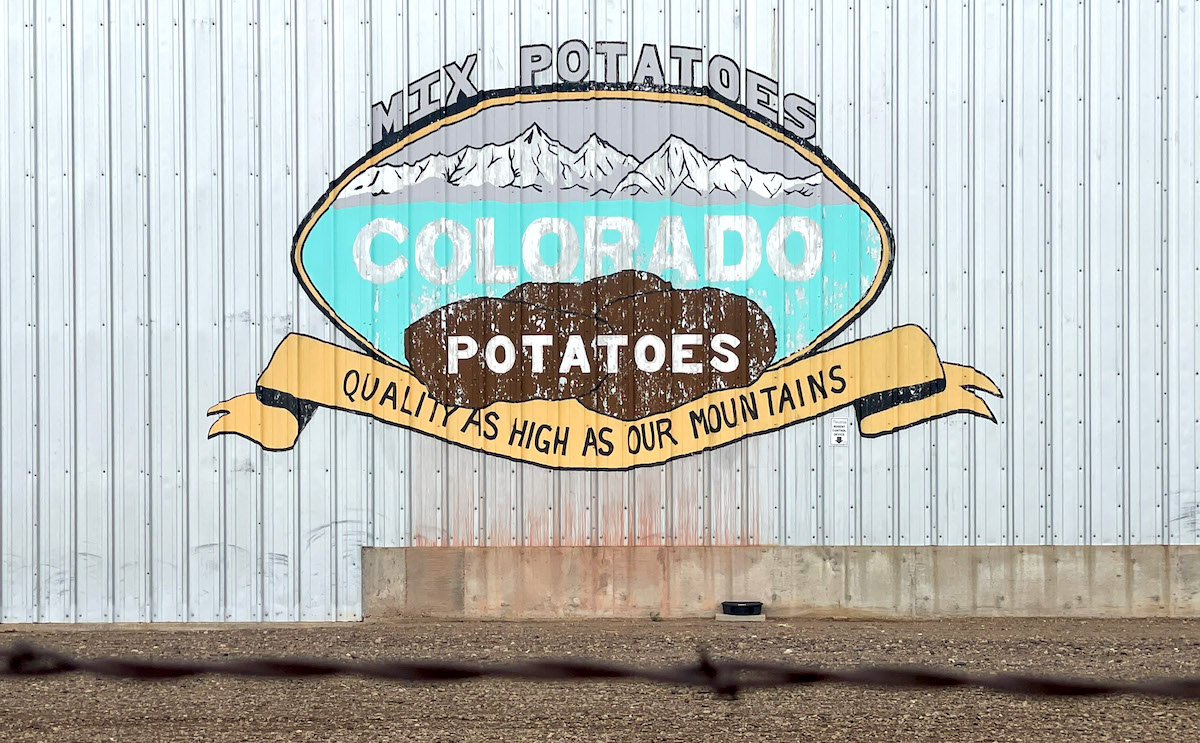 An advertisement for Colorado potatoes painted on the side of a shed in Center, Colo. on June 30, 2022.
